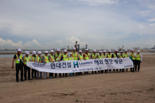 현대건설 우수 협력사 관계자들이 현대건설 싱가폴 투아스 핑거1 매립공사 현장에서 기념촬영을 하고 있다.<현대건설 제공>